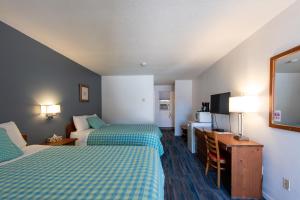 a hotel room with two beds and a television at Chase Country Inn in Chase