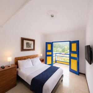 a bedroom with a bed and a balcony at Hospedaje Camino Real in Salento