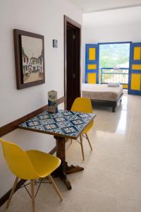 a room with a table and chairs and a bed at Hospedaje Camino Real in Salento