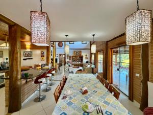 a dining room and kitchen with a table and chairs at Mirantes Paraibuna - Casa Vermelha in Paraibuna