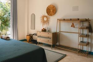 a bedroom with a bed and a dresser and a mirror at Maralagua in Puerto Escondido