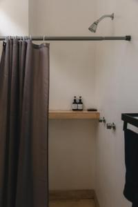 a shower with a shower curtain and a sink at Maralagua in Puerto Escondido