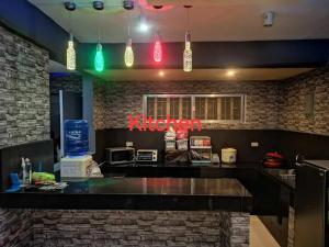 a kitchen with a bar with neon signs on the wall at McHanns Place in Antipolo