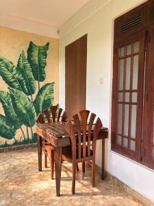 a wooden table and chairs next to a wall with a mural at Mountain Shack Homestay in Ella