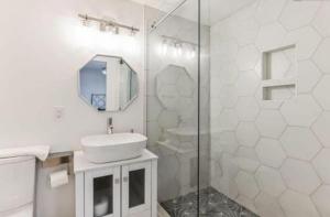 a white bathroom with a sink and a shower at Sweet Home in Greenville +33 photos