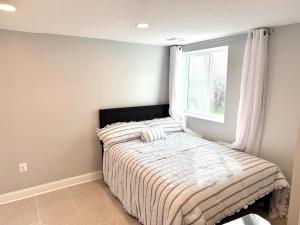 a bed in a bedroom with a window at Prime DMV Stay in Silver Spring