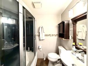 a bathroom with a toilet and a sink and a shower at Prime DMV Stay in Silver Spring +13 photos