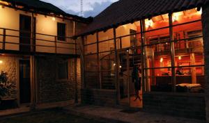 a house with a lit up facade at night at Terra Alta Lodge in Yanque