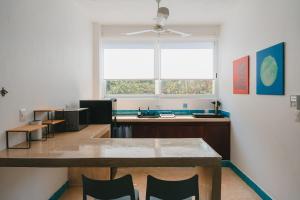 a kitchen with a table and chairs and a window at Maralagua in Puerto Escondido