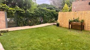 a backyard with a wooden fence and a grass yard at Piccolo Posto in Neuquén