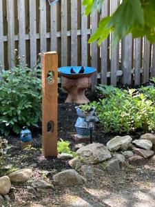 a birdbath in a garden with a bird feeder at Historic Block Island Suite in New Shoreham