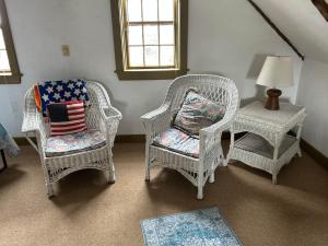 a room with three wicker chairs and a table at Historic Block Island Suite in New Shoreham