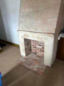 a brick fireplace in the corner of a room at Historic Block Island Suite in New Shoreham