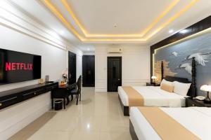 a hotel room with two beds and a television at The Elegant Boutique - Hue in Hue