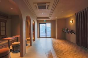 a room with a corridor with chairs and a window at SABLIER by R HOTEL in Osaka
