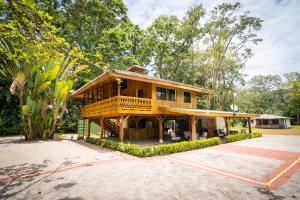 a large wooden house with a porch at Bungalows Beachfront Hotel in Punta Uva