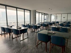 a dining room with tables and chairs and windows at One Budget Hotel Chiangrai Chiangsaen 2 in Ban Wiang Nuea