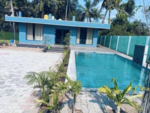 a villa with a swimming pool in front of a house at hariholidaysvilla in Chennai