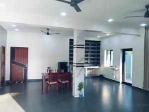 a living room with a table and chairs and a door at hariholidaysvilla in Chennai