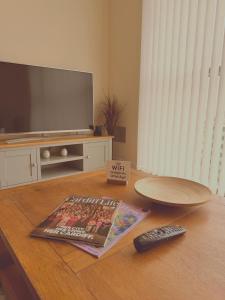 a living room with a television and a remote control at Cardiff City Center - FREE On-Site Parking in Cardiff