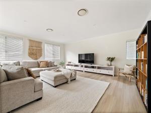 a living room with a couch and a tv at Baudin Beach House in Gnarabup
