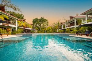 a swimming pool in front of a resort at Bungalows Beachfront Hotel in Punta Uva