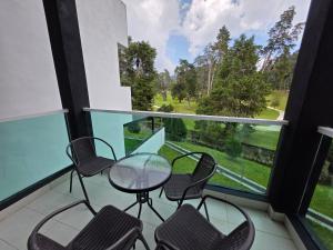 a balcony with four chairs and a glass table at Teeview Homes 9B in Tanah Rata