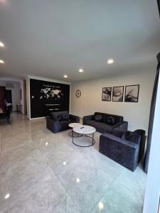 a living room with two couches and a table at Teeview Homes 9B in Tanah Rata
