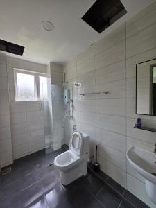 a bathroom with a toilet and a sink at Teeview Homes 9B in Tanah Rata +3 photos
