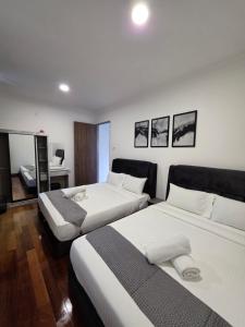 a hotel room with two beds and a desk at Teeview Homes 9B in Tanah Rata
