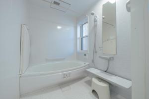 a white bathroom with a tub and a sink at Quiet Japanese House near Airport in Kumamoto