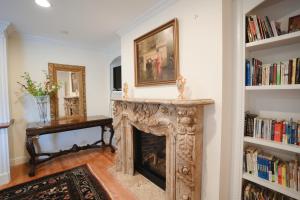 a fireplace in a living room with bookshelves at Snow Circle Retreat in Bourne