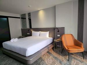 a bedroom with a large bed and a chair at One Budget Hotel Chiangrai Chiangsaen 2 in Ban Wiang Nuea +67 photos