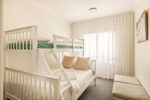 a white bedroom with a bunk bed and a couch at Baudin Beach House in Gnarabup +73 photos