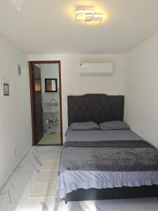 a bedroom with a large bed and a mirror at Suites Du'Mauro Terreo in Abraão