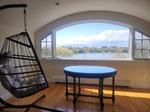 a swing in a room with a large window at Snow Circle Retreat in Bourne