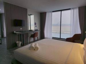 a hotel room with a bed with two towels at One Budget Hotel Chiangrai Chiangsaen 2 in Ban Wiang Nuea
