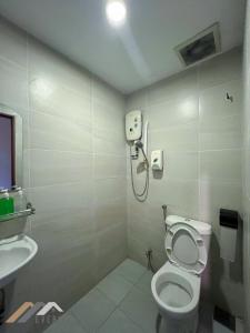 a bathroom with a toilet and a phone on the wall at Everstay Inn by Evernent in Miri