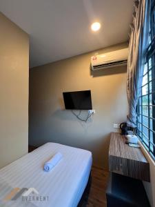 a small room with a bed and a tv at Everstay Inn by Evernent in Miri