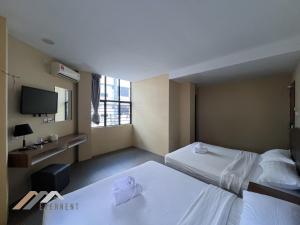 a hotel room with two beds and a tv at Everstay Inn by Evernent in Miri