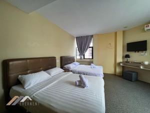 a hotel room with two beds with white sheets at Everstay Inn by Evernent in Miri +22 photos