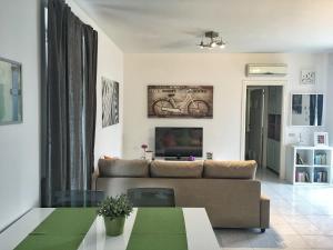 een woonkamer met een bank en een tv bij Casa Rosa in Sorrento