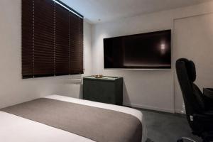 a bedroom with a bed and a flat screen tv at Daejeon Anook Hotel Yuseong Oncheon Station in Daejeon