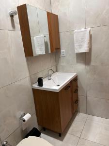 a bathroom with a sink and a mirror and a toilet at Casa Mobiliada Conforto e Praticidade in Santa Rosa +11 photos