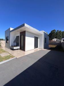 a white house with a black roof at Casa Mobiliada Conforto e Praticidade in Santa Rosa
