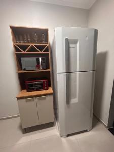 a white refrigerator in a kitchen with a microwave at Casa Mobiliada Conforto e Praticidade in Santa Rosa