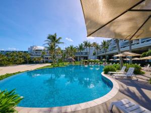 a swimming pool with chairs and umbrellas at a resort at Palace In Moon Beach in Onna