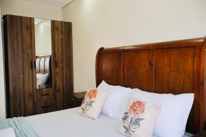 a bedroom with a bed with white pillows and a wooden headboard at Studio Getaway in Cebu City Baseline in Cebu City +16 photos