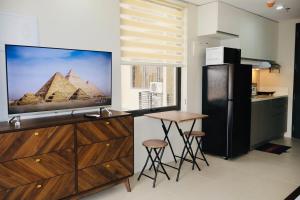 a kitchen with a large tv and a table with stools at Studio Getaway in Cebu City Baseline in Cebu City