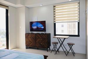 a bedroom with a bed and a television on a dresser at Studio Getaway in Cebu City Baseline in Cebu City